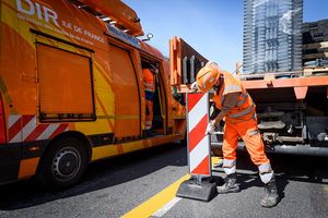 Pose de plots par un agent d'exploitation sur le chantier d'aménagement de la piste cyclable temporaire entre la Porte Maillot et La Défense © Arnaud Bouissou / Terra